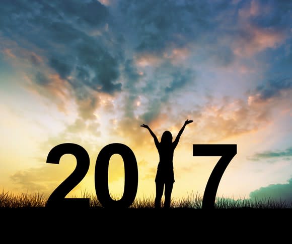 Silhouette of 2017 with woman holding hands up in place of the one