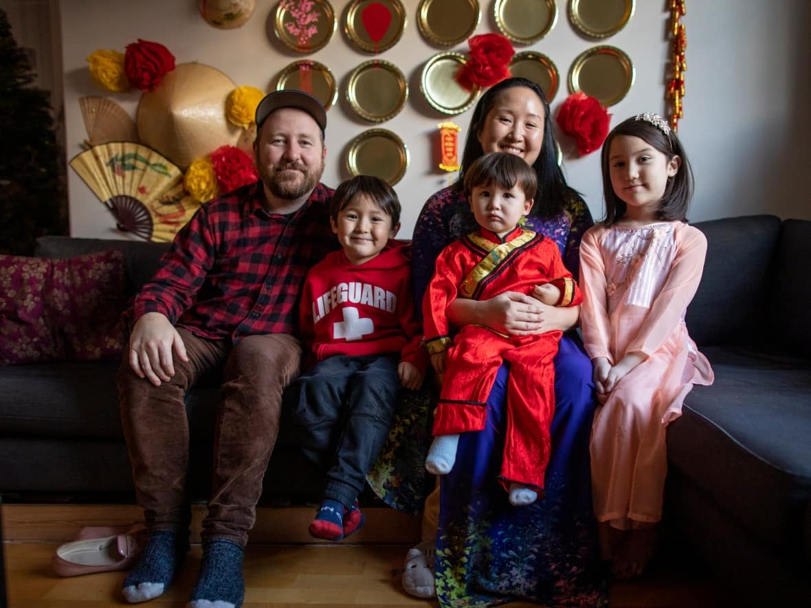 Kim Phan Nguyễn-Stone, second from right, is pictured with her husband Dave and their children John, 6, Moses, 2, and Raphaela, 8, at their Vancouver home adorned with Vietnamese Lunar New Year decorations.  (Ben Nelms/CBC - image credit)