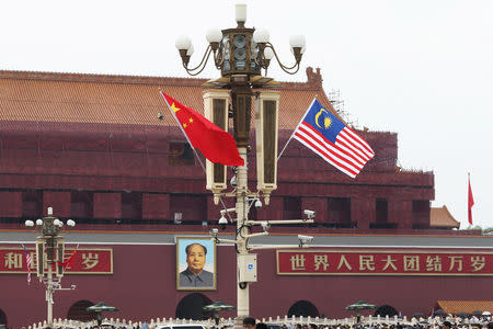A Malaysian flag flutters next to a Chinese flag (L) as Malaysian Prime Minister Mahathir Mohamad visits China, at Tiananmen Square in Beijing, China August 19, 2018. REUTERS/Stringer