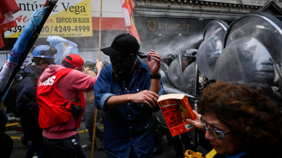 Police spray demonstrators during a protest near the National Congress