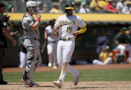 Oakland Athletics' Seth Brown (15) crosses home plate in front of Minnesota Twins' Ryan Jeffers (27) in the third inning of a baseball game in Oakland, Calif., on Wednesday, May 18, 2022. (AP Photo/Scot Tucker)