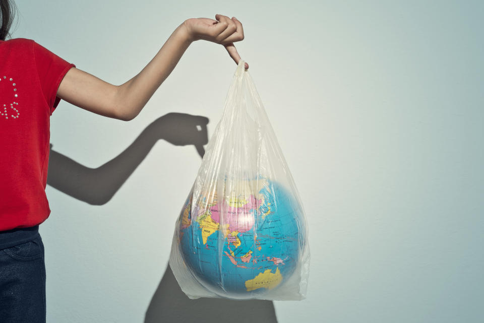 Little girl holding a plastic bag with a globe inside