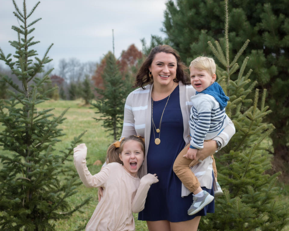 Whitney smiling for a picture outside with her two children