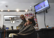 <p>Barber William Moore gives 4-year-old DJ Alexander a haircut at the Hands On Barber Shop in Mount Rainier, Md. </p>