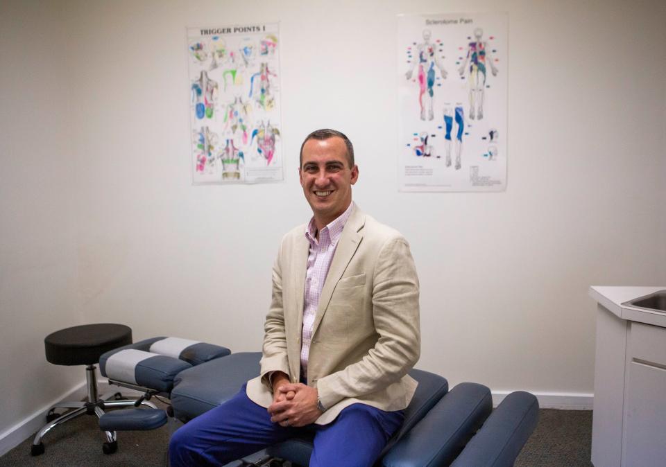 Justin Bruce, real estate agent and oner of Bruce Chiropractic, sits in one of the exam rooms at Bruce Chiropractic in Lancaster, Ohio on April 6, 2022.