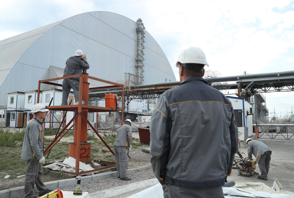 A worker takes measurements outside the giant enclosure that encases reactor number four at the Chernobyl nuclear power plant (Getty Images)