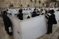 Ultra-Orthodox Jewish men pray ahead of the Jewish new year at the Western Wall, the holiest site where Jews can pray in Jerusalem's old city, Wednesday, Sept. 16, 2020. A raging coronavirus outbreak is casting a shadow over the normally festive Jewish New Year. With health officials recommending a nationwide lockdown, traditional family gatherings will be muted, synagogue prayers will be limited to small groups and roads will be empty. (AP Photo/Sebastian Scheiner)