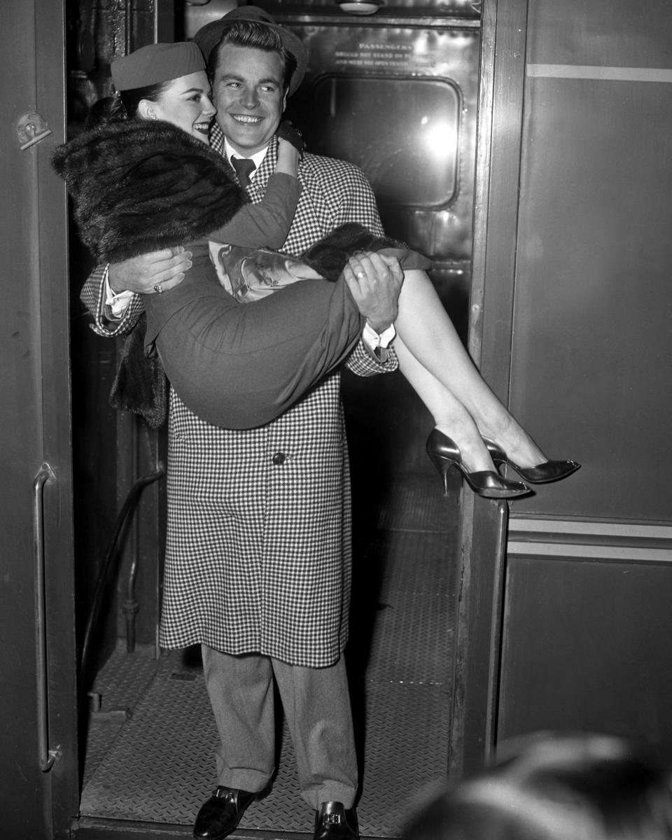 <p>Natalie Wood gets a lift from her husband Robert Wagner, as they arrive at Penn Station for their honeymoon.</p>