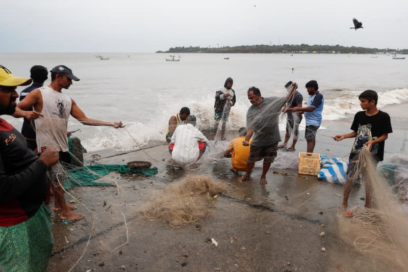 Fishermen gather their nets by the sea shore to store them before cyclone Nisarga makes its landfall, in Mumbai