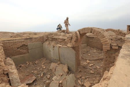 FILE PHOTO: A member of the Iraqi army walks on the remains of structures destroyed by Islamic State militants in the Assyrian city of Nimrud, south of Mosul, Iraq, November 16, 2016. REUTERS/Ari Jalal/File Photo