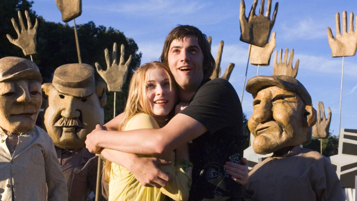 a man and woman posing with a group of people in clothing