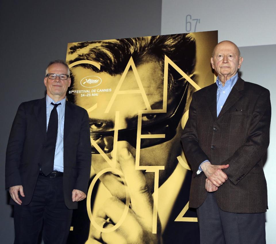 Cannes Film Festival general delegate Thierry Fremaux, left, and Festival President Gilles Jacob, right, pose next to the poster of the Festival, at the end of a press conference to announce this years line up in Paris, Thursday April 17, 204. A Tommy Lee Jones western and a David Cronenberg exposé on Hollywood are among the 18 films vying for the top prize at the Cannes Film Festival. The festival organizers also said Thursday that two women directors and famed New Wave filmmaker Jean-Luc Godard will be in competition at the festival that runs May 14-25.(AP Photo/Remy de la Mauviniere)