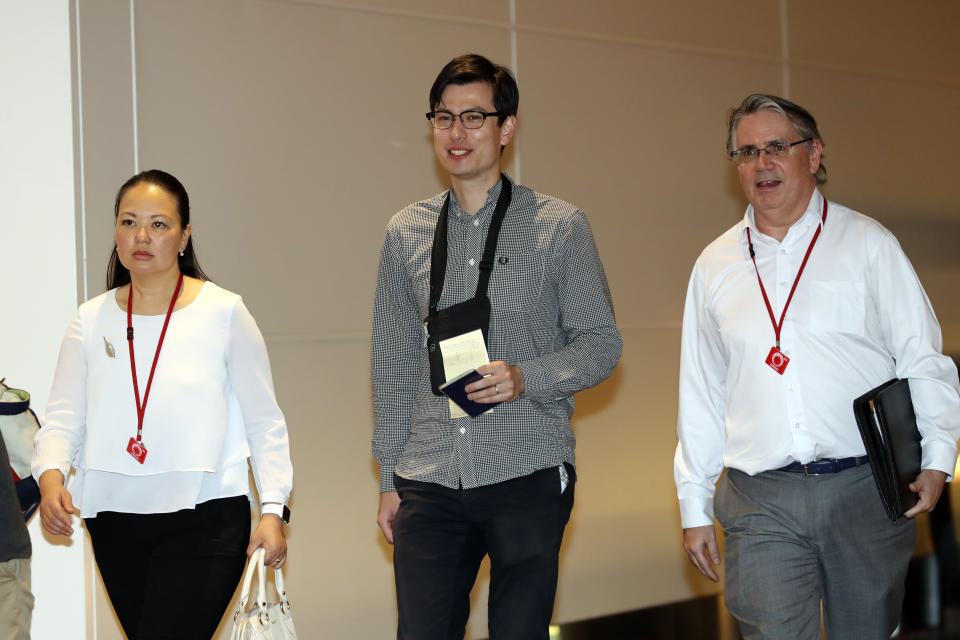 Australian student Alek Sigley, center, is escorted as he arrives at the airport in Tokyo on Thursday, July 4, 2019. The Australian student who vanished in North Korea more than a week ago arrived in Tokyo Thursday, July 4, 2019. (AP Photo/Eugene Hoshiko)
