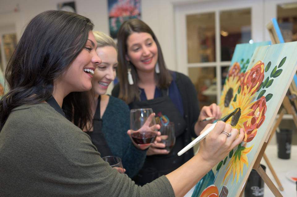 This 2019 photo provided by Painting with a Twist shows a group during a Painting with a Twist event in Mandeville, La. In recent years, the interactive painting industry has become a global sensation. Around the world, adults can spend their nights out learning to paint in a relaxed, BYOB setting. Thousands of franchises exist to help us all unleash our inner creative. (Painting with a Twist via AP)