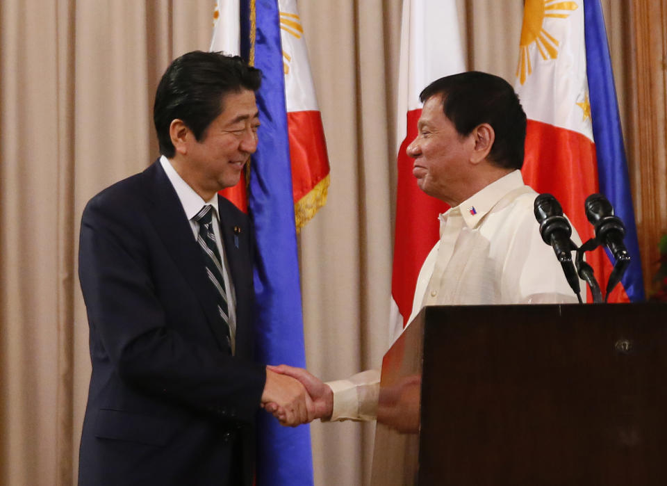 Japanese Prime Minister Shinzo Abe, left, shakes hands with Philippine President Rodrigo Duterte following their joint statement at the Malacanang Palace, Thursday, Jan. 12, 2017, in Manila, Philippines. Abe arrived Thursday for a two-day official visit that includes a visit to Duterte's hometown of Davao city in southern Philippines. (AP Photo/Bullit Marquez)