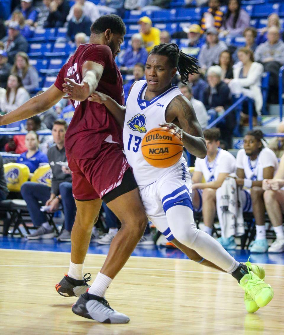 Delaware forward Jyare Davis (13) is fouled by Rider's Tariq Ingraham in overtime in the Blue Hens' 88-85 overtime loss at the Bob Carpenter Center, Wednesday, Dec. 20, 2023.