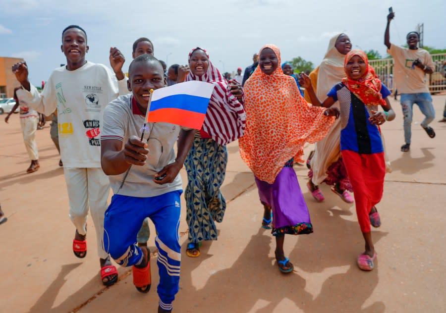 Supporters of Niger’s ruling junta hold a Russian flag in Niamey, Niger, Sunday, Aug. 6, 2023. Nigeriens are bracing for a possible military intervention as time’s run out for its new junta leaders to reinstate the country’s ousted president. (AP Photo/Sam Mednick)