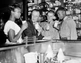 <p>Evangelist Billy Graham enjoys an ice cream soda with a group of teenagers after discussing the problem of juvenile crime with a group of youngsters at a New York City news conference on Aug. 8, 1957. At the Hotel New Yorker, Graham proposed that passages from the Bible be read “in every classroom in New York City” as a way of combating teenage crime. (Photo: AP) </p>