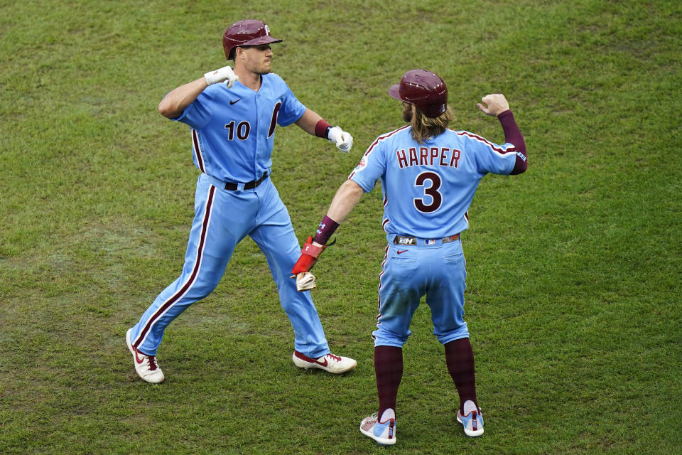 Philadelphia Phillies' J.T. Realmuto, left, and Bryce Harper celebrate after Realmuto's two-run home run off Baltimore Orioles pitcher Tom Eshelman during the fourth inning of a baseball game, Thursday, Aug. 13, 2020, in Philadelphia. (AP Photo/Matt Slocum)