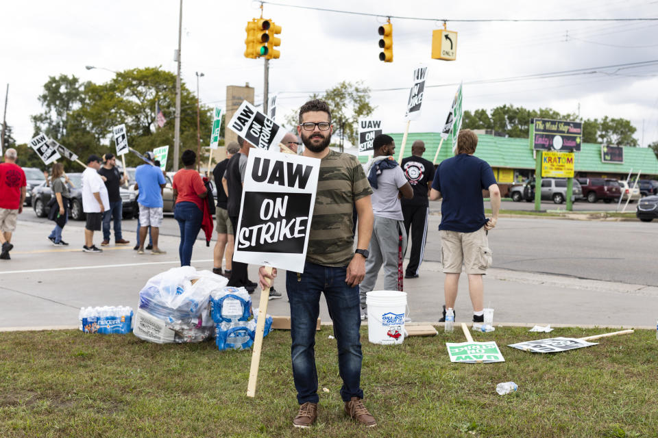 In this Monday, Sept. 16, 2019, photo Joe Drumm, who has been with General Motors for 12 years, stands outside of GM plants with other union members picketing in Flint, Mich.  More than 49,000 members of the United Auto Workers went on strike Monday against General Motors, bringing more than 50 factories and parts warehouses to a standstill in the union's first walkout against the No. 1 U.S. automaker in over a decade. (Sara Faraj/The Flint Journal via AP)