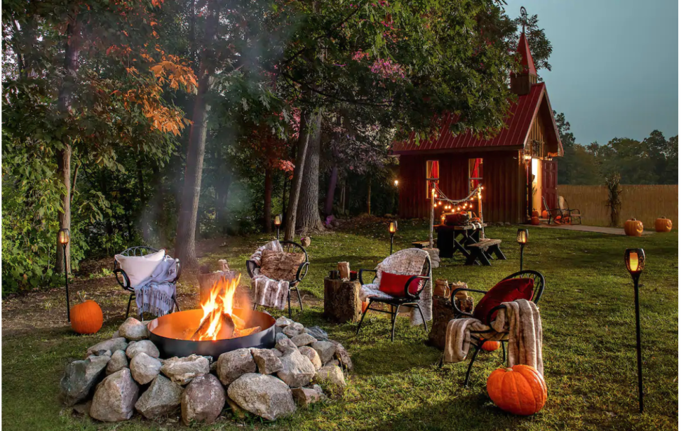An outdoor movie screen area and fire pit. (Photo: Airbnb)