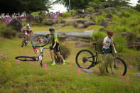 Jaqueline Mourao of Brazil picks up her bike after falling as she competes with Daniela Campuzano Chavez Peon of Mexico, right, andMaja Wloszczowska of Poland (21) during the women's cross-country mountain bike competition at the 2020 Summer Olympics, Tuesday, July 27, 2021, in Izu, Japan. (AP Photo/Christophe Ena)