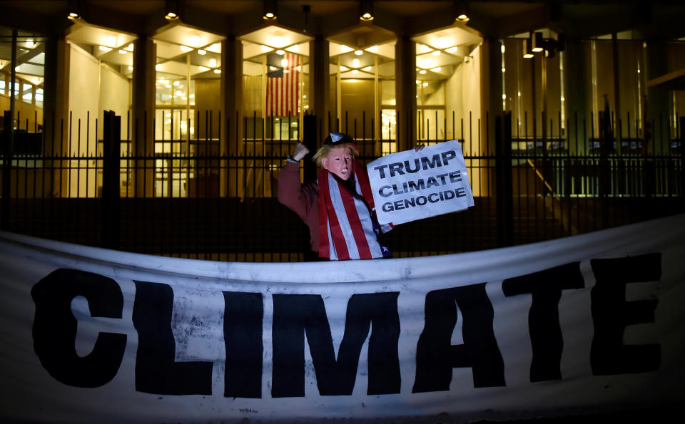 A man wearing a mask depicting Donald Trump protests during a demonstration against climate change outside of the U.S. Embassy in London, Britain, 18 November, 2016. (REUTERS/Hannah McKay)