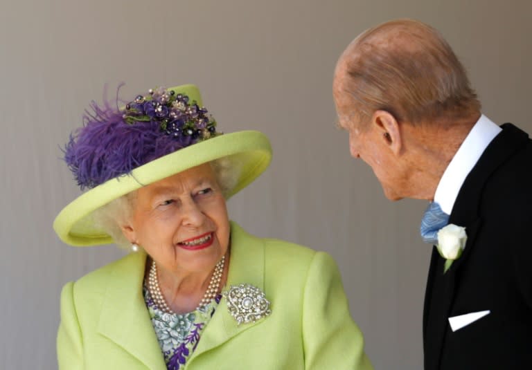 Queen Elizabeth II talks with Prince Philip as they leave after attending the wedding
