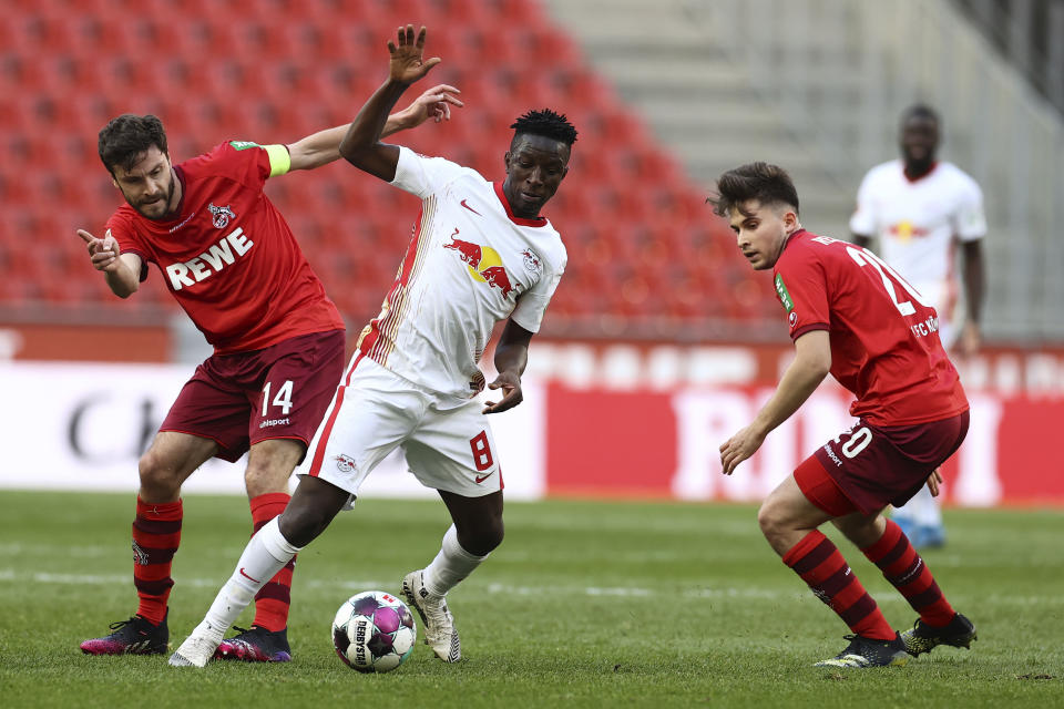 Jonas Hector y Elvis Rexhbeçaj de Colonia en acción con Amadou Haidara del Leipzig en el encuentro del martes 20 de abril del 2021. (Rolf Vennenbernd/Pool via AP)