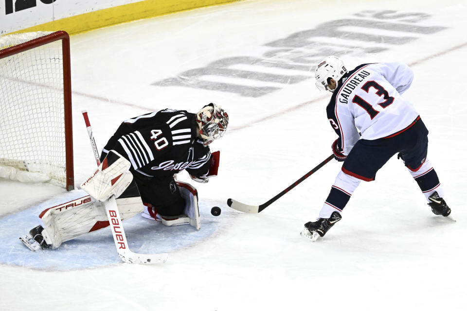 New Jersey Devils goaltender Akira Schmid (40) stops a shot by Columbus Blue Jackets left wing Johnny Gaudreau (13) during the third period of an NHL hockey game Friday, Nov. 24, 2023, in Newark, N.J. (AP Photo/Bill Kostroun)