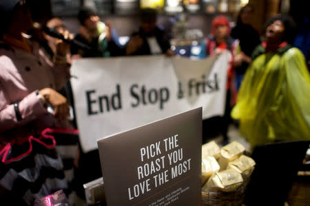 A Starbucks coffee beans roast sign is posted inside in front of protestors demonstrating with a "End Stop & Frisk" sign inside a Center City Starbucks, where two black men were arrested, in Philadelphia, Pennsylvania, U.S., April 16, 2018. REUTERS/Mark Makela