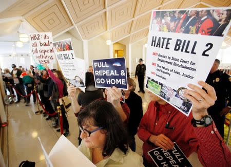 Opponents of North Carolina's HB2 law limiting bathroom access for transgender people protest in the gallery above the state's House of Representatives chamber as the legislature considers repealing the controversial law in Raleigh, North Carolina, U.S. on December 21, 2016. REUTERS/Jonathan Drake