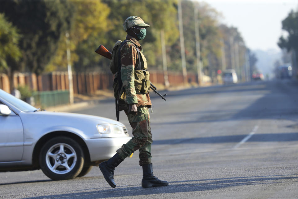 An armed soldier is seen on a street in Harare, Friday, July, 31, 2020. Zimbabwe's capital, Harare, was deserted Friday, as security agents vigorously enforced the country's lockdown amidst planned protests. Police and soldiers manned checkpoints and ordered people seeking to get into the city for work and other chores to return home. (AP Photo/Tsvangirayi Mukwazhi)