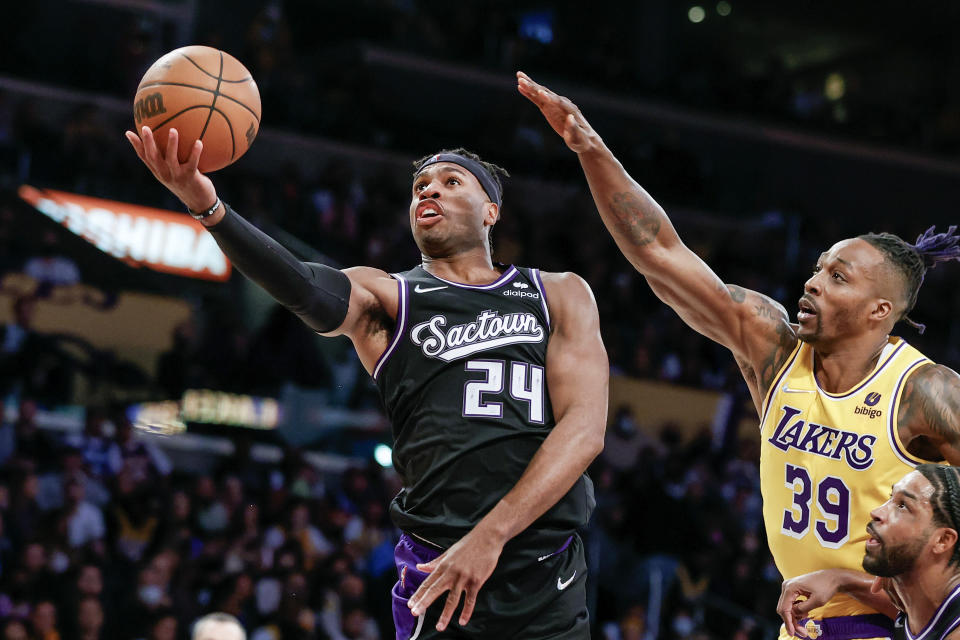 Sacramento Kings guard Buddy Heild (24) goes to basket while defended by Los Angeles Lakers center Dwight Howard (39) during the second half of an NBA basketball game in Los Angeles, Friday, Nov. 26, 2021. The Kings won 141-137 in triple overtime. (AP Photo/Ringo H.W. Chiu)