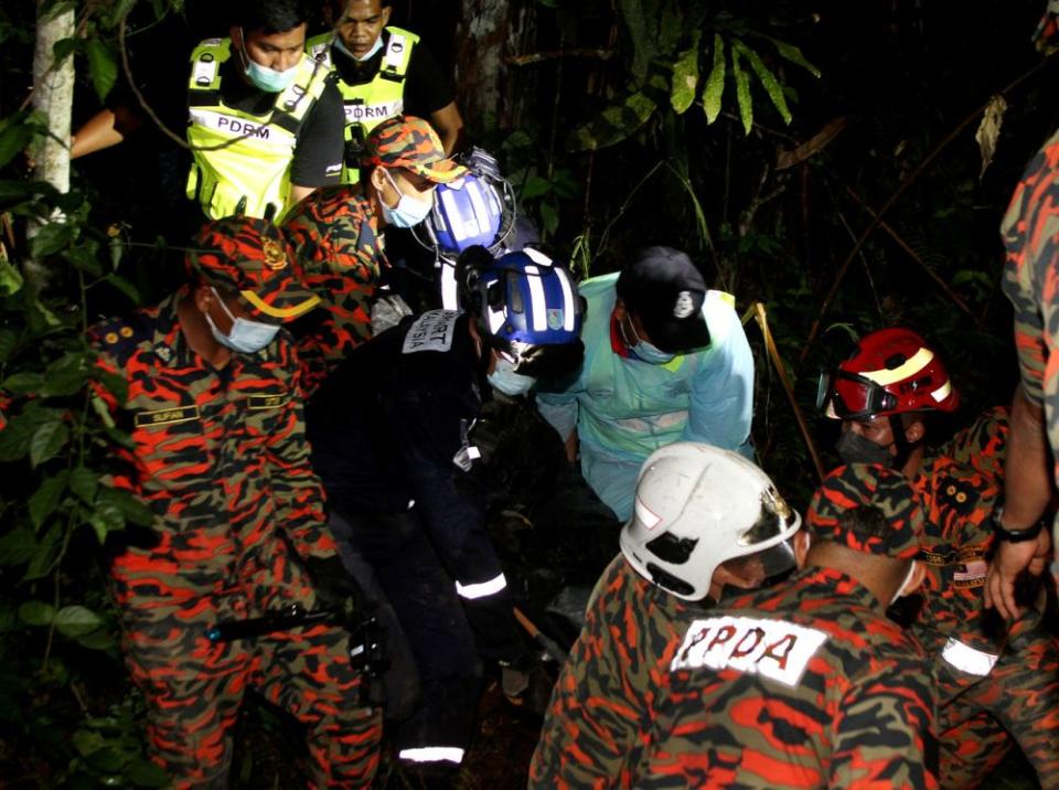 Search and rescue personnel recover the body of an MPV driver who was buried under the landslide in Cameron Highlands, December 2, 2021. — Bernama pic