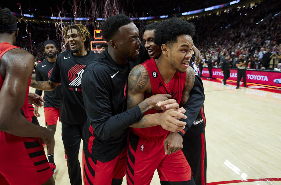 Portland Trail Blazers guard Anfernee Simons, front, is congratulated by forward Nassir Little, left, and forward Jabari Walker after the team's NBA basketball game against the Phoenix Sun in Portland, Ore., Friday, Oct. 21, 2022. (AP Photo/Craig Mitchelldyer)