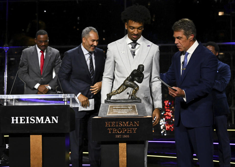 Chris Fowler presents LSU quarterback Jayden Daniels the college football's Heisman Trophy award Saturday, Dec. 9, 2023, in New York. (Todd Van Emst/Pool Photo via AP)