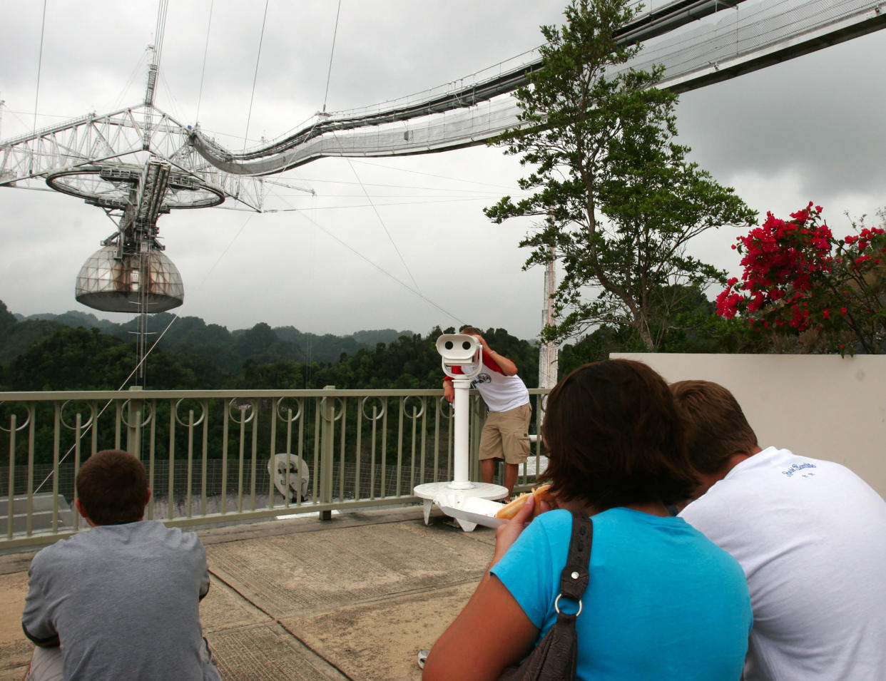 Visitantes ven el radiotelescopio más grande del mundo en el Observatorio de Arecibo en Arecibo, Puerto Rico, el 22 de abril de 2006. (Barbara P. Fernandez/The New York Times)