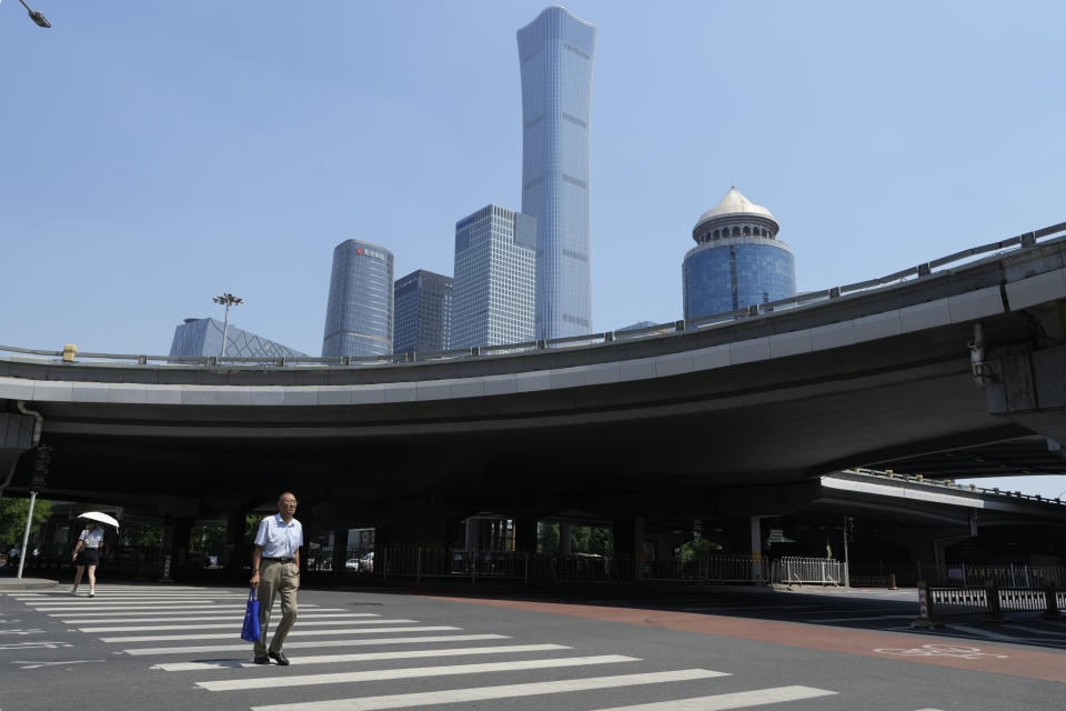 A man crosses the road near the central business district in Beijing, Monday, July 17, 2023. China's economy grew at a 6.3% annual pace in the April-June quarter, much lower than analysts had forecast given the slow pace of growth the year before. (AP Photo/Ng Han Guan)