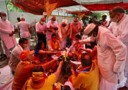 Hindus offer prayers for a groundbreaking ceremony of a temple dedicated to the Hindu god Ram in Ayodhya, at the Vishwa Hindu Parishad, or World Hindu Council, headquarters in New Delhi, India, Wednesday, Aug. 5, 2020. The coronavirus is restricting a large crowd, but Hindus were joyful before Prime Minister Narendra Modi breaks ground Wednesday on a long-awaited temple of their most revered god Ram at the site of a demolished 16th century mosque in northern India. (AP Photo/Manish Swarup)