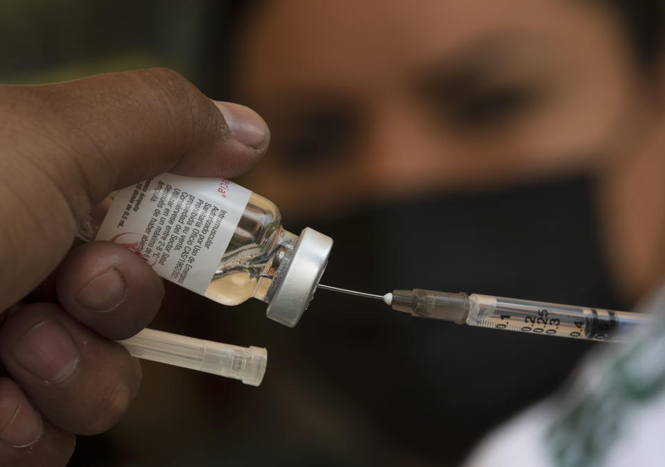 A healthcare worker prepares a dose of the CanSino COVID-19 vaccine, during a vaccination campaign for educators on the grounds of the National Polytechnic Institute, in Mexico City, Tuesday, May 18, 2021. Mexico is mounting a final push to get all of the country's school teachers vaccinated so that it can reopen schools, perhaps by June. (AP Photo/Marco Ugarte)