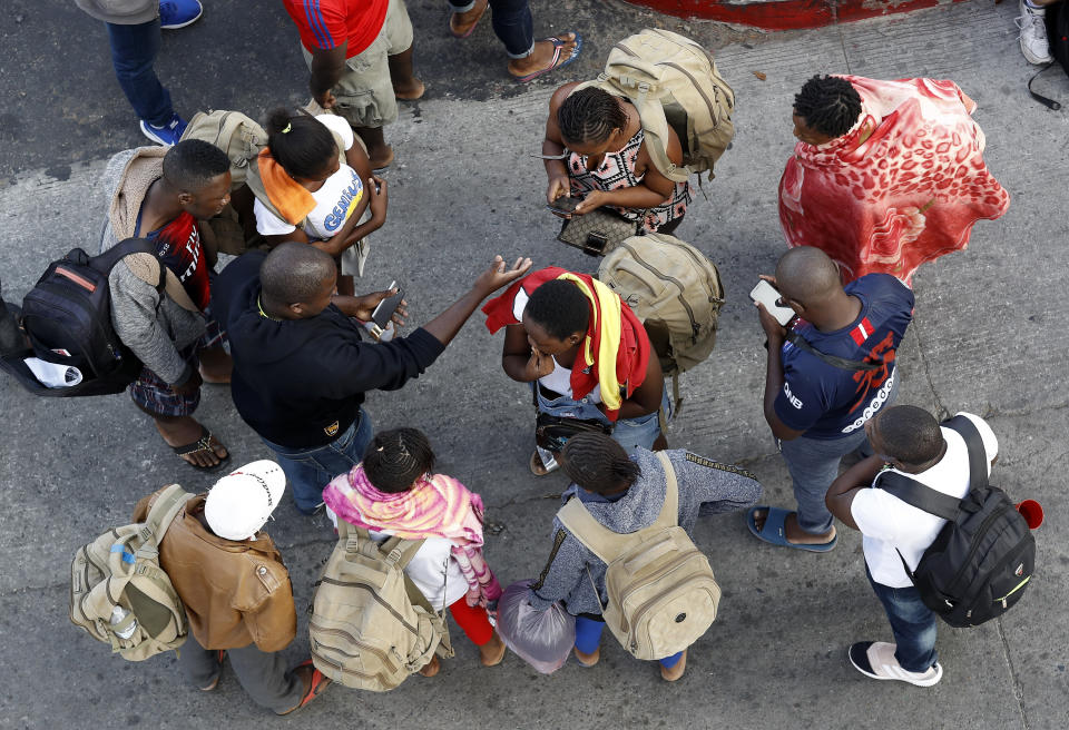 FILE - In this Thursday, July 16, 2020, file photo, people gather as they wait to apply for asylum in the United States along the border in Tijuana, Mexico. In its efforts to remake the U.S. immigration system, the Trump administration has often stumbled over an obscure law that governs how administrative policies are made. Its latest test is a mammoth proposal to severely limit access to asylum, which invited nearly 80,000 public comments before the Wednesday, July 15, 2020, deadline to offer feedback. (AP Photo/Gregory Bull, File)