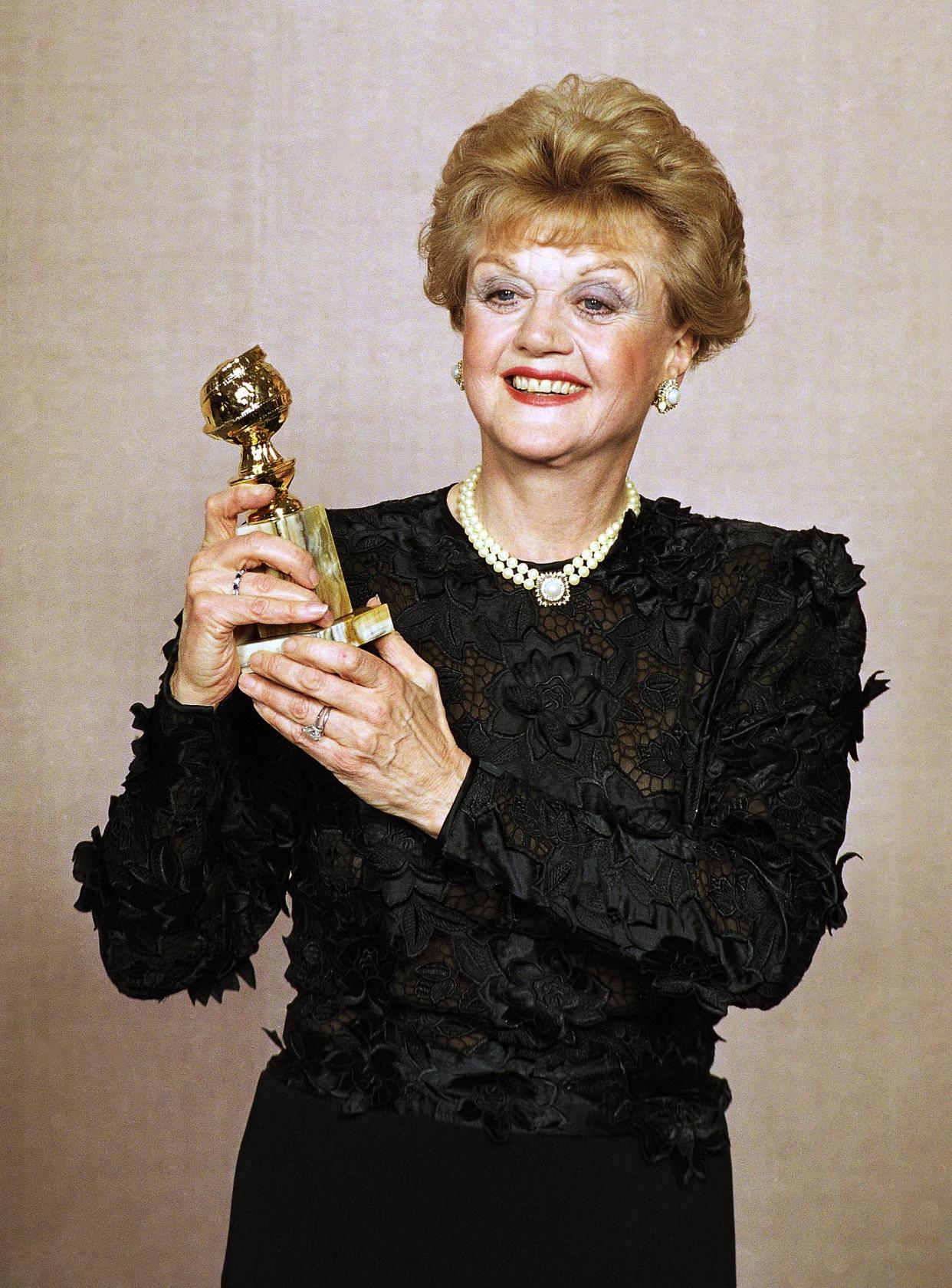 Angela Lansbury displays her Golden Globe Award for best actress in a television drama series for "Murder She Wrote" at the 47th Annual Golden Globe Awards on Jan. 21, 1990, in Beverly Hills, Calif. 