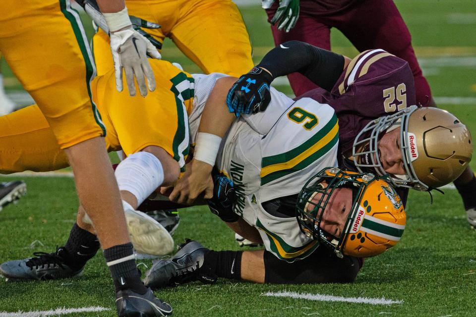 Indian River quarterback Dylan Grise hangs on to the ball while being tackled by St. Elizabeth's Chase Milnes on Sept. 15.