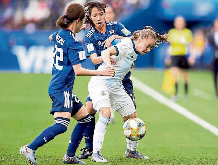 Estefanía Banini cubre la pelota ante dos japonesas