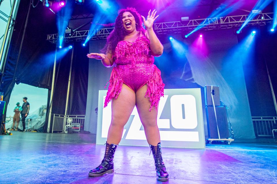 Lizzo on stage in a hot pink outfit
