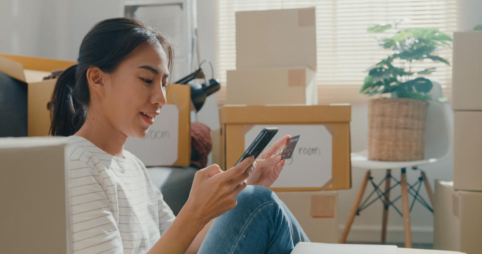 woman holding a smartphone and a credit card