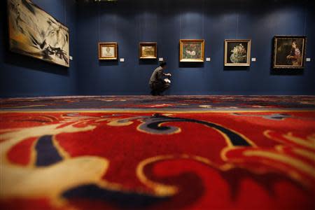 A member of staff cleans a wall prior to the opening of an auction preview of 'modern and contemporary Chinese art' during Sotheby's Beijing Art Week in Beijing, November 28, 2013. REUTERS/Kim Kyung-Hoon