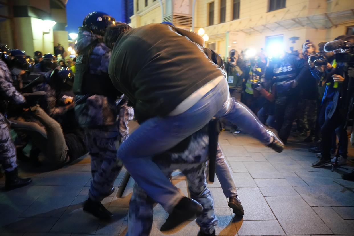 A demonstrator jumps on a police officer