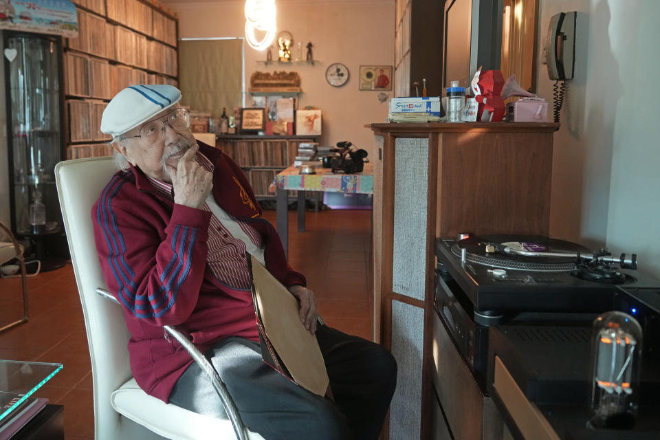 FILE - Ray Cordeiro, Hong Kong's oldest DJ, listens music at his home in Hong Kong, Thursday, May 27, 2021. Cordeiro, who interviewed music acts including the Beatles during a six-decade career on Hong Kong radio that earned him the title of the world's longest-working disc jockey, died Friday, Jan. 13, 2023, his former employer announced. He was 98. (AP Photo/Kin Cheung, File)